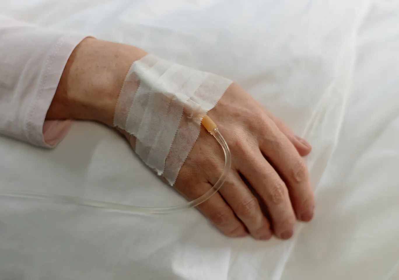 Kroplówki witaminowe Serock: dłoń z podłączoną kroplówką w spokojnym kadrze