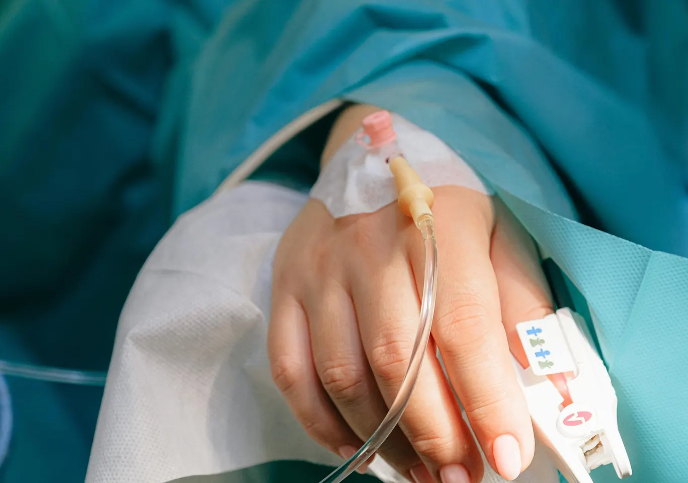 Detoks alkoholowy Józefowie: dłoń z wenflonem i pulsoksymetrem pod nadzorem