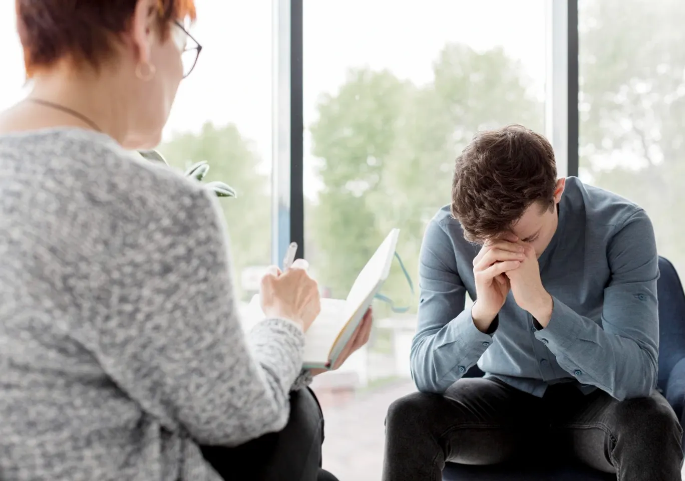 Terapia uzależnień Warszawa: konsultacja u terapeuty przy oknie
